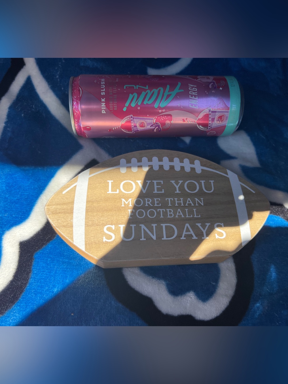Source Unknown Pink and Teal Energy Drink Can with Football Shaped Wood Sign